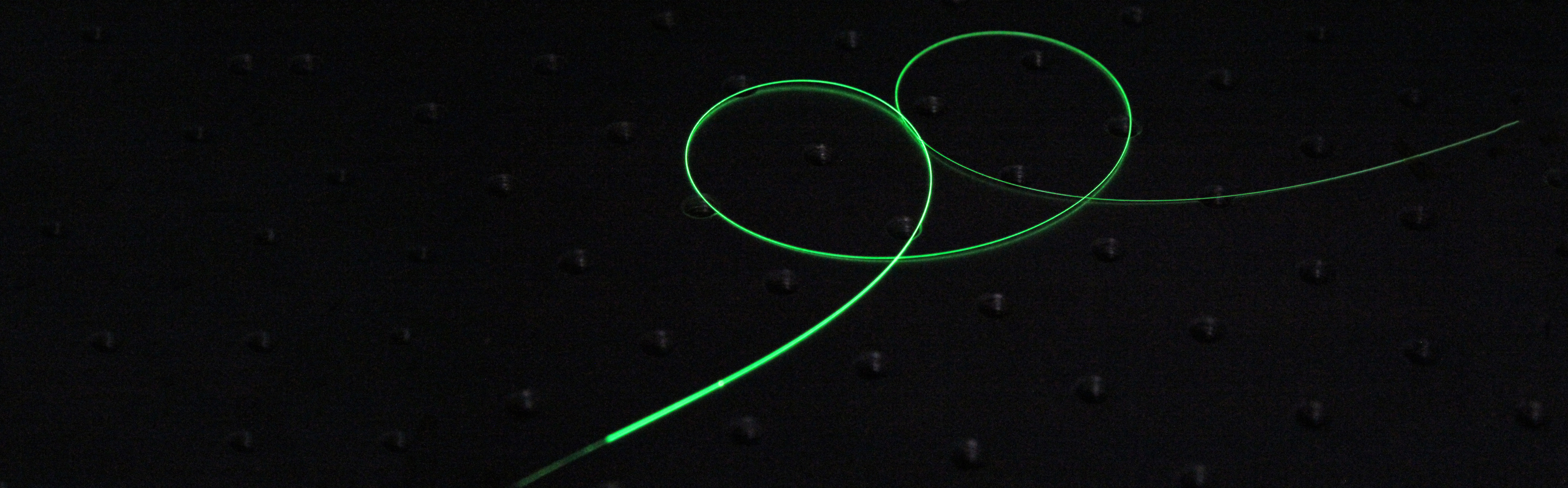Charakteristisches grünes Leuchten einer aktiven Faser, die eine zentrale Komponente des SLAPCOPS-Lasersystems darstellt.