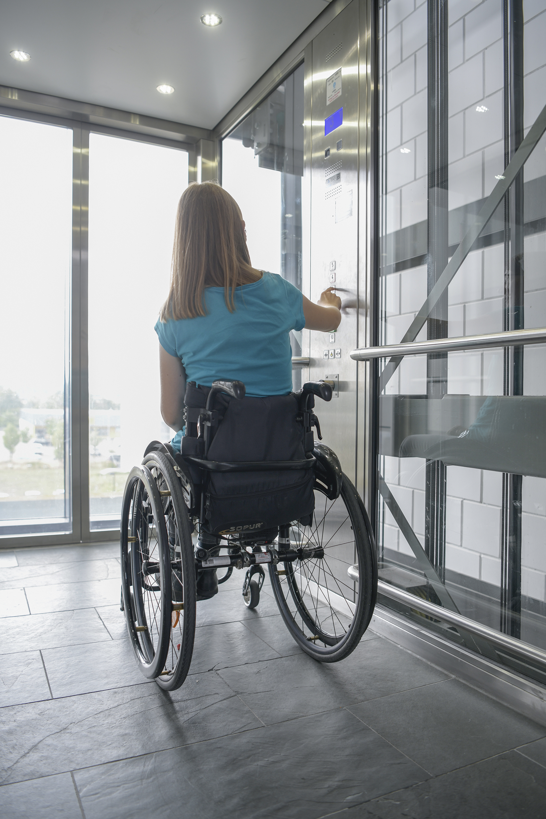 Arbeiten mit Behinderung am Fraunhofer ITWM im Aufzug: Frau im Rollstuhl fährt Aufzug am Fraunhofer ITWM.